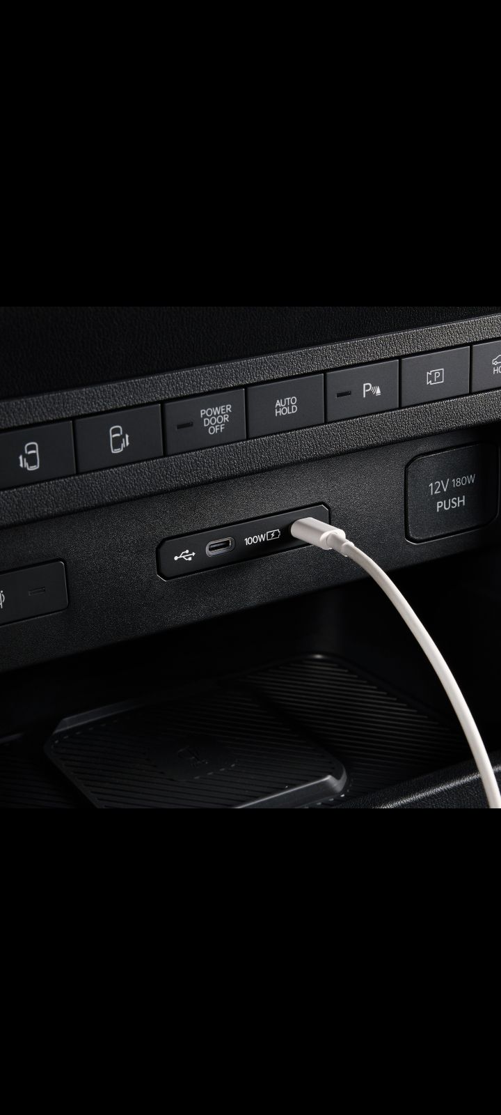 Nahaufnahme des USB-Anschlusses im Armaturenbrett des Kia PV5 Cargo mit angeschlossenem Kabel.